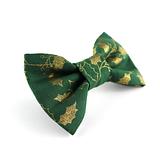 angled view of green Christmas dog bow tie with gold holly leaves on a white background