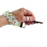 daisy flower keyring on ladies wrist, hand holding a key
